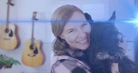 Smiling Woman Hugging Dog at Home with Acoustic Guitars