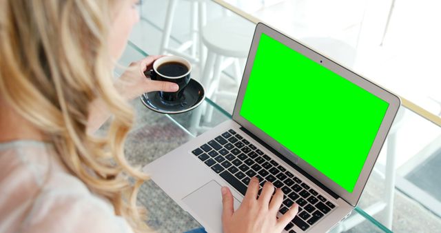 Woman using laptop while having coffee in restaurant 