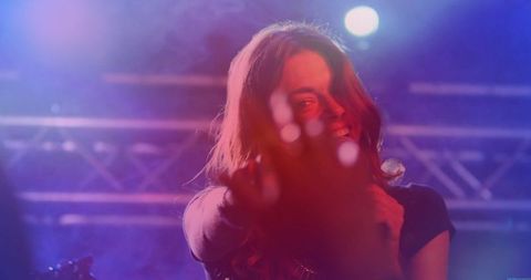 Energetic Female Singer Perform at Live Concert with Vibrant Haze