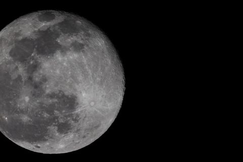 Detailed view of full moon in night sky with craters visible