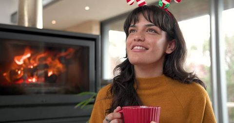 Woman Enjoying Cozy Fireplace with Festive Accents