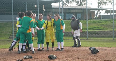 Diverse Softball Team Gathering on Mound Showing Unity
