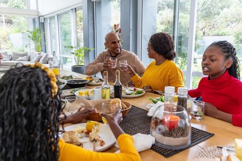 African american family enjoying cozy home meal in bright dining room with garden view