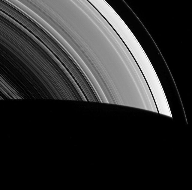 Image captures Saturn's F ring with moon Prometheus seen as a dot within its rings. Taken by NASA Cassini spacecraft in 2014, this image showcases the 'shepherding' effect where Prometheus and another moon, Pandora, help to confine the F ring. It is a powerful depiction of space phenomena and is ideal for educational materials, scientific research, and astronomical presentations.