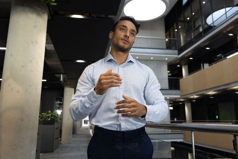 Businessman Posing Elegantly in Modern Office Atrium
