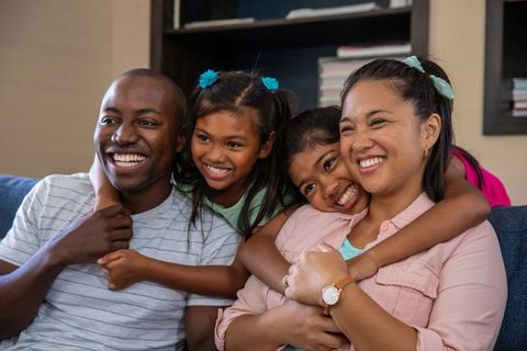Happy Diverse Family Hugging in Cozy Living Room Setting