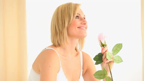 Smiling Woman Enjoying Fresh Rose at Home