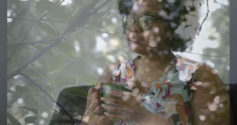 Woman relaxing with coffee amidst nature reflections