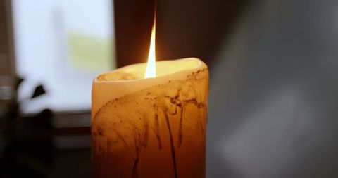 Serene Candle Flame Illuminating Soft-Hued Room Ambience