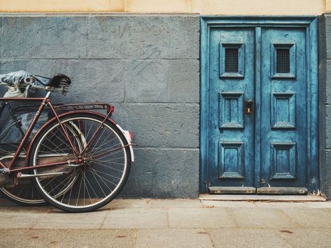 Vintage Bicycle Resting Against Weathered Blue Doorway