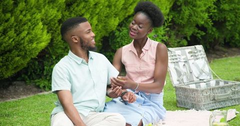 African American Couple Enjoying Picnic and Taking Selfie in Sunny Park