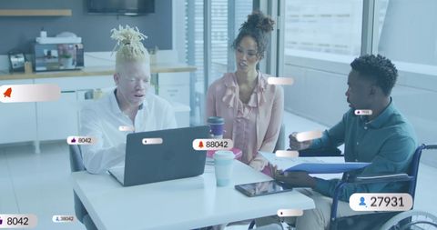 Diverse Coworkers Discussing Social Media Strategy in Modern Office