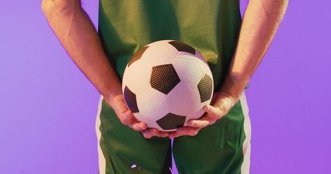 Soccer Player Holding Ball Against Vibrant Background - Download Free Stock Images Pikwizard.com