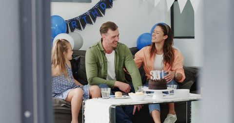 Family Celebrating Birthday with Cake and Joyful Smiles