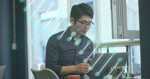 Asian businessman analyzing digital data with dna overlay