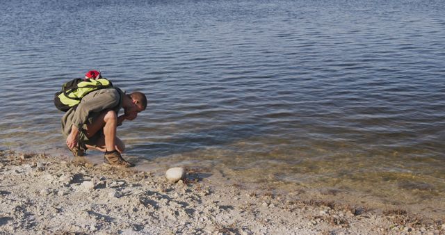 Explorer Curiously Examining Water by Shoreline - Download Free Stock Photos Pikwizard.com