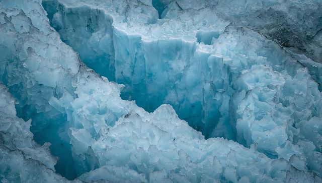 Revealing deep glacial crevasse with jagged seracs and crystalline blue ice walls