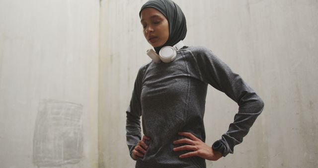 Focused Female Athlete Wearing Hijab and Headphones Taking a Break - Download Free Stock Images Pikwizard.com