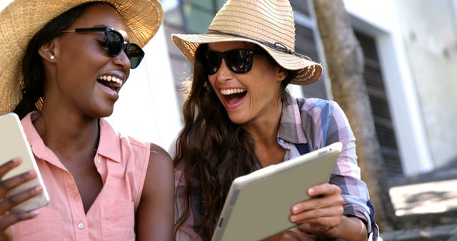 Two Friends Laughing Outdoors Exploring Content on Digital Devices - Download Free Stock Images Pikwizard.com