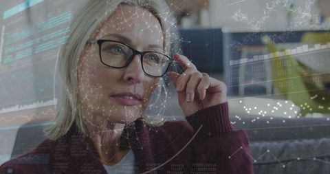 Woman analyzing data with digital overlays on sofa