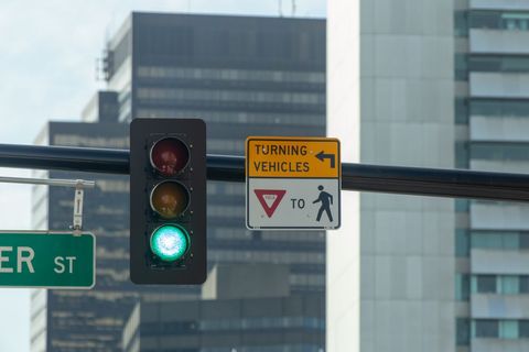Urban traffic light with safety sign in city