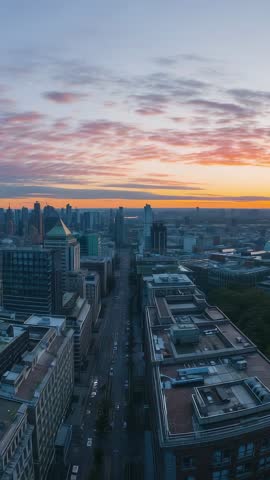 Vertical dusk skyline filming rooftop perspective with street lamps switching on