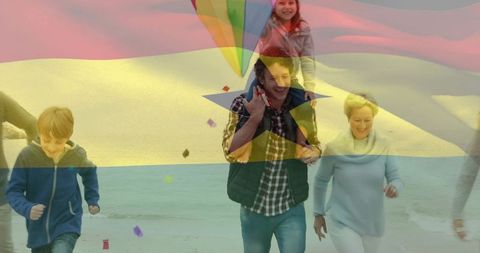 Family running on beach carrying daughter on shoulders with colorful kite flag overlay
