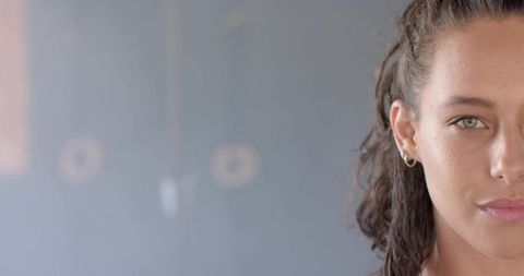 Half-Face Portrait Woman with Pulled-Back Hair Hoop Earring Gray-Blue Minimalist Background