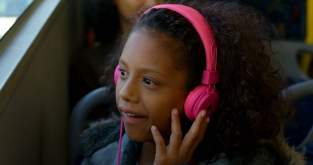 Young Girl Listening to Music with Pink Headphones on a Bus - Download Free Stock Images Pikwizard.com