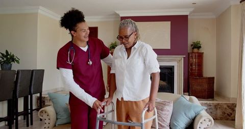 Caregiver Assisting Senior with Mobility in Comfortable Living Room