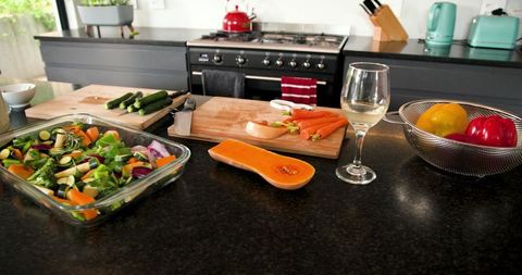 Modern Kitchen with Vibrant Vegetables and Wine Glass for Gourmet Cooking