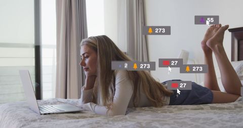 Woman Relaxing on Bed Using Laptop with Social Media Notifications