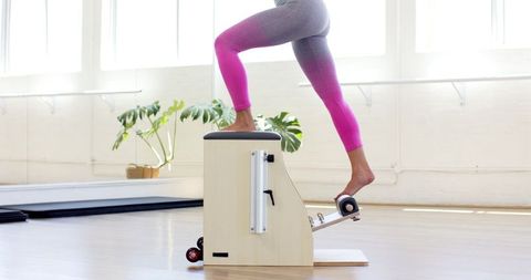 Woman Exercising on Pilates Wunda Chair in Bright Studio