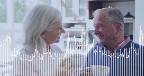 Senior couple sharing coffee while monitoring heart health data overlay