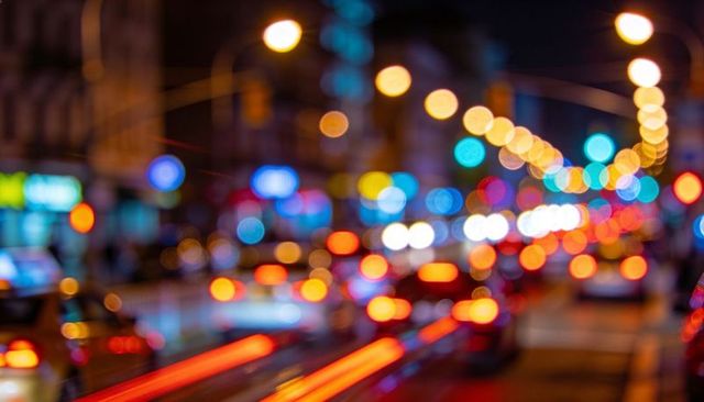 Blurred city traffic night taillight streaks colorful bokeh neon lights