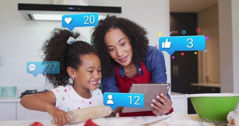 Mother and Daughter Cooking Together with Digital Assistance