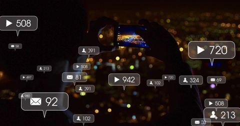 Silhouetted woman capturing city skyline smartphone at night with social media overlays