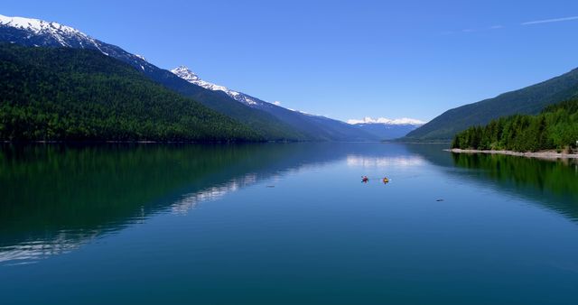 Kayakers enjoy the serene waters of a mountain-lined lake, with copy space - Download Free Stock Photos Pikwizard.com