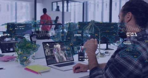 Global Data Collaboration: Man Viewing Video Call on Laptop with Holographic Map Overlay
