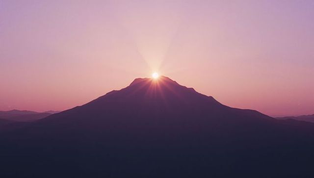 Radiant Sunrise Silhouette Over Mountain