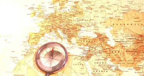 Compass on vintage map of europe highlighting travel and adventure