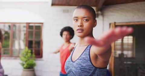 Focused Woman Practicing Yoga Outdoors with Diverse Group