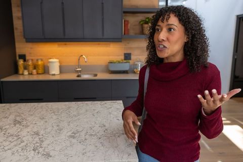 Confident Woman Speaking in Modern Kitchen with Marble Countertop