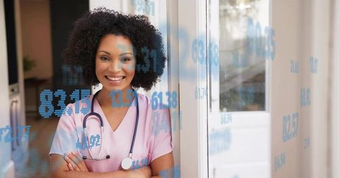 Confident nurse in pink scrubs standing at clinic glass door with blue data overlay