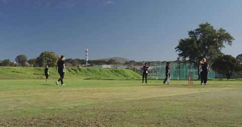 Women Enjoying Cricket Game on Vibrant Green Field