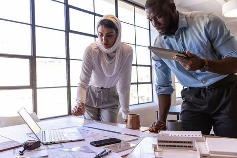 Diverse professionals reviewing architectural blueprints in modern office