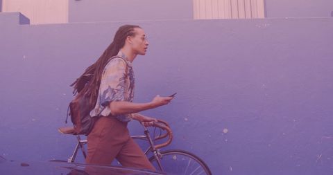 Man walking with bicycle using smartphone urban surreal pastel