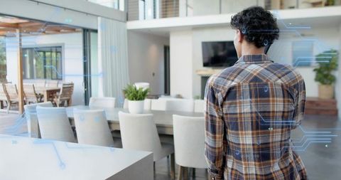 Man standing in modern open-plan kitchen with augmented reality overlays, smart home ui