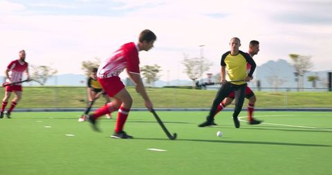 Field hockey players in intense match on turf field