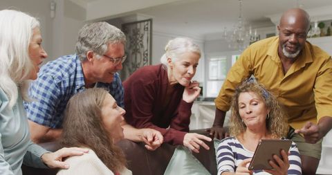 Happy Senior Friends Enjoy Tablet Together at Home
